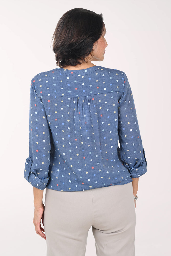 Woman wearing a blue patterned blouse with a white background