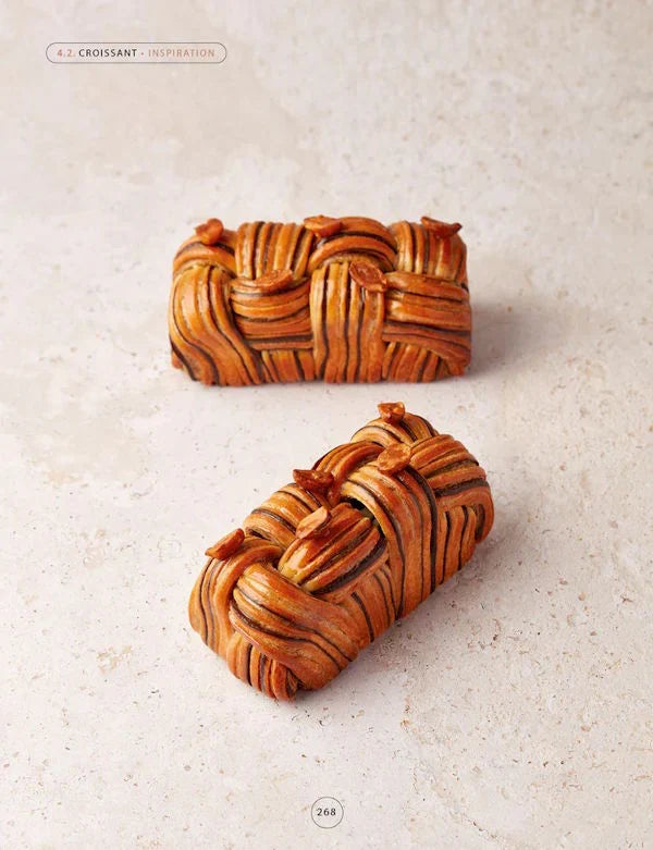 Two braided pastries on a textured beige surface