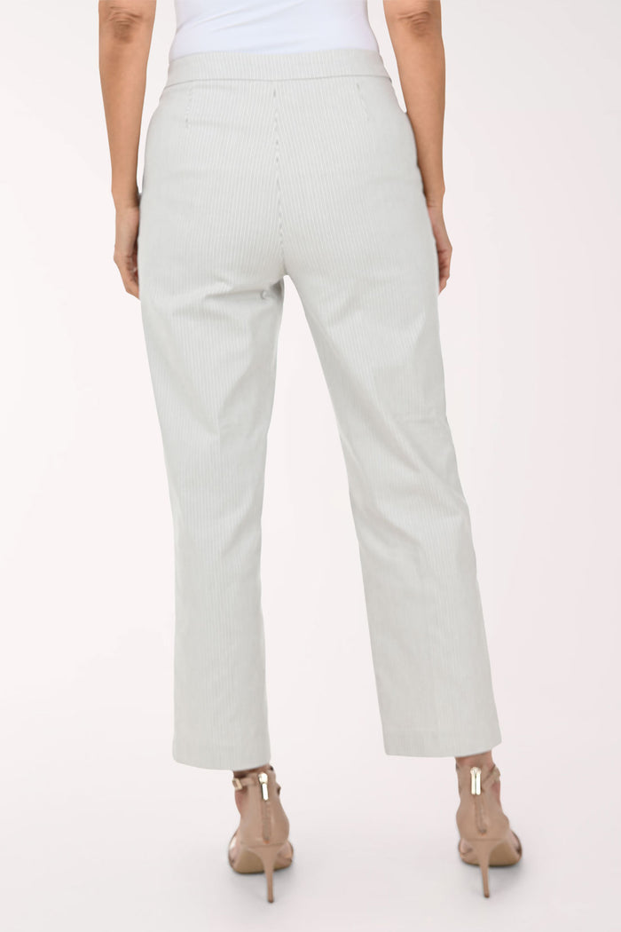 A model wearing light sage green pinstriped trousers with decorative gold buttons on the sides, paired with beige strappy high-heeled sandals against a plain white background.
