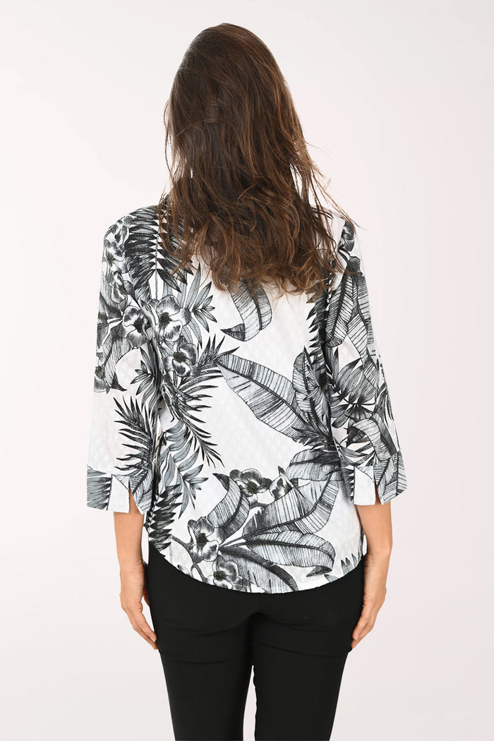 Woman wearing a black and white floral blouse with a white background