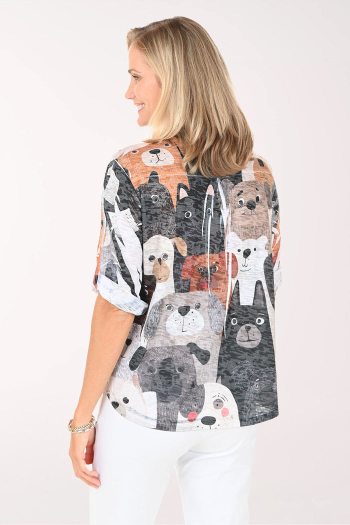 Woman wearing a patterned blouse with animal faces on a white background