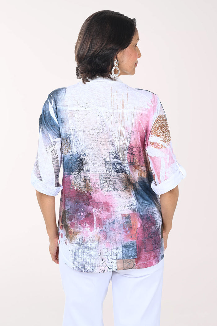 Woman wearing a colorful patterned blouse with a plain background