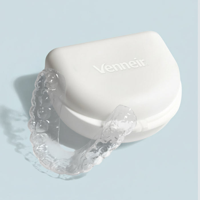 Clear upper teeth whitening tray with dosing dots on blue background