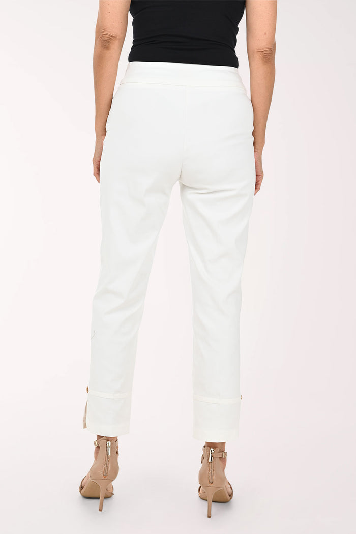 White cropped ankle pants with rolled cuffs and small side zippers, shown on a model wearing beige strappy heels against a plain light background.