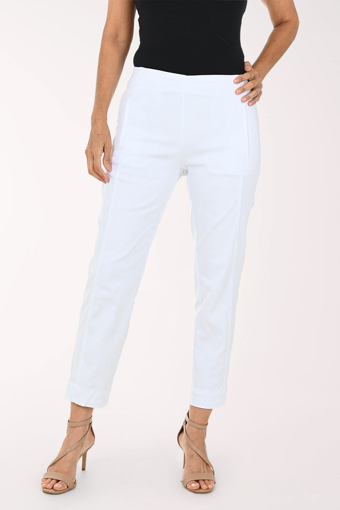 A model wearing white cropped pants with a black top and beige strappy high-heeled sandals, shown from the waist down against a plain light background.