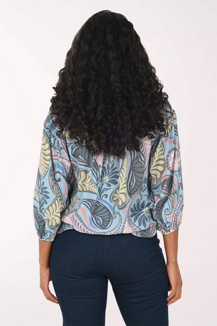 Woman wearing a patterned blouse with a white background