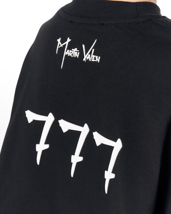 Close-up of the back of a black Martin Yaren sweatshirt featuring a white stylized signature logo and the number '777' printed in white.