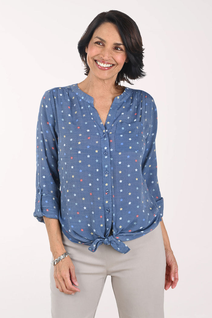 Woman wearing a blue patterned blouse with a white background