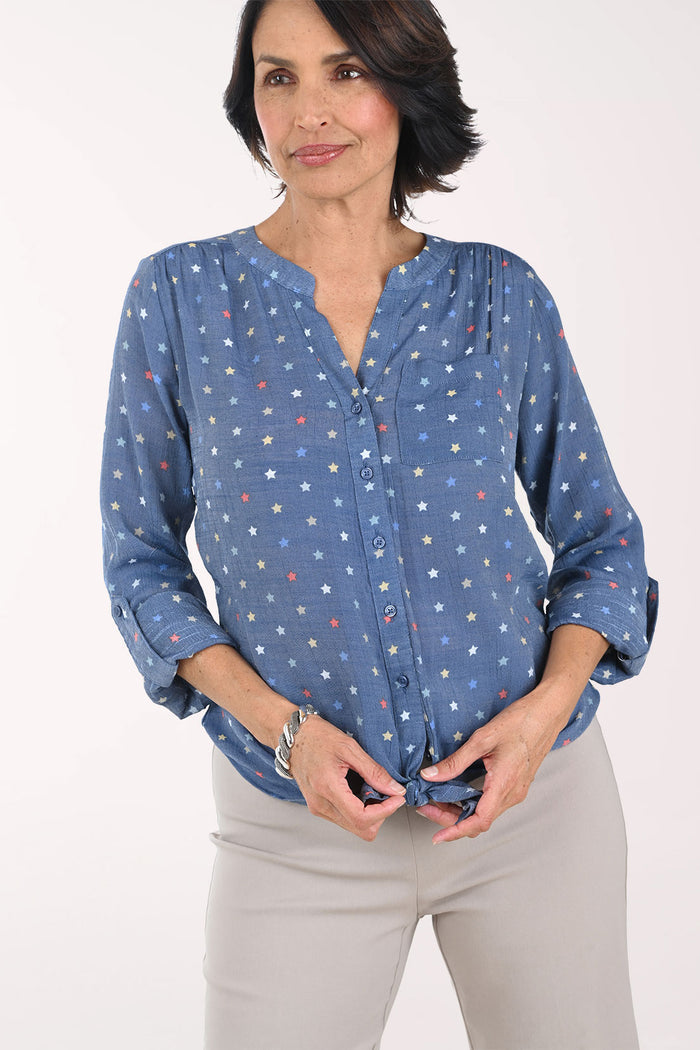Woman wearing a blue patterned blouse with a white background