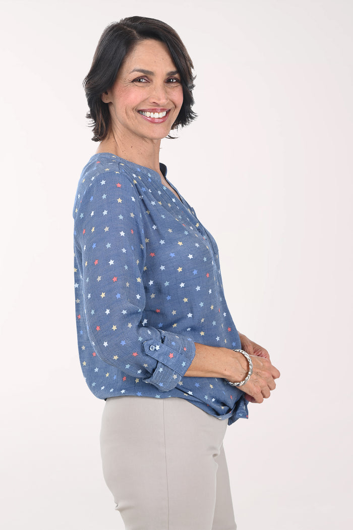 Woman wearing a blue patterned blouse with a white background