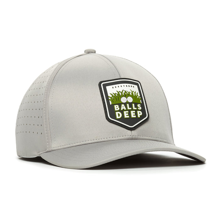The Bogey Bros Balls Deep - Performance Golf Hat - Stretch Fit is a light gray cap with a curved brim, ventilation holes, and stretch band. The front features "BALLS DEEP" on a patch with green grass and two golf balls.