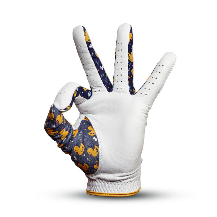 The Big Duck Energy - Glove is a white cabretta leather golf glove with dark blue lining and a yellow rubber duck pattern, designed in an OK sign for comfort, precision fit, and standout style on the course.