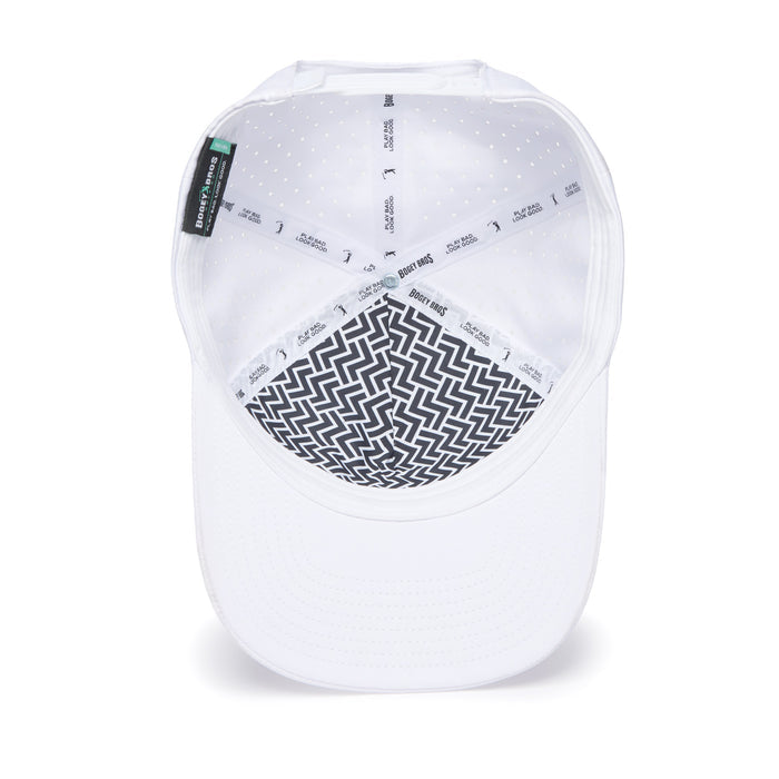 The image features the Bogeyman - White/White Performance Golf Hat, a snapback cap displayed upside-down. Inside, it has a black-and-white zigzag liner, a white sweatband with gray logos, small ventilation holes, and the brim at the bottom.