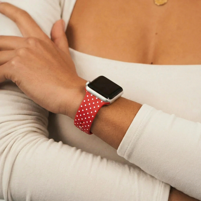 Burgundy polka dot Apple Watch strap by Coconut Lane on wrist, paired with a white long-sleeve top.