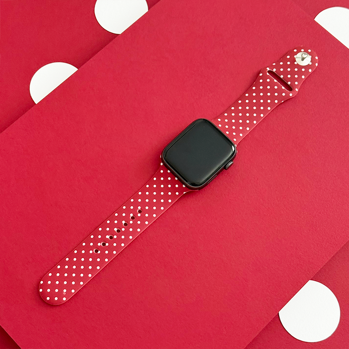 Burgundy Apple Watch strap with white polka dots and a smooth, glossy finish.