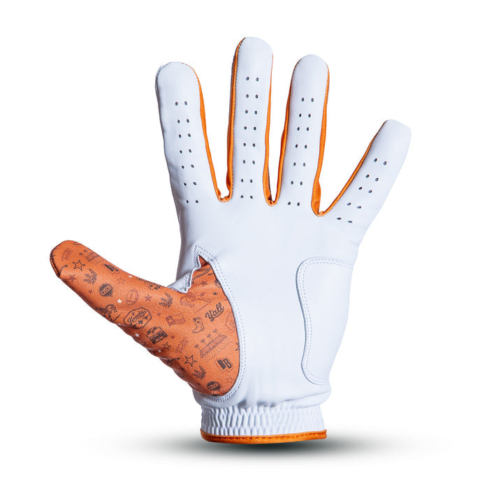 A white golf glove with orange trim and brown palm, displayed palm up. The thumb features various small printed icons and symbols. The glove has ventilation holes on each finger and a fitted wrist. The background is plain white with a subtle shadow.
