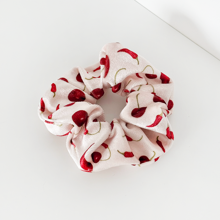 Red Cherry Spice scrunchie with soft fabric and cherry print, displayed on a white surface.