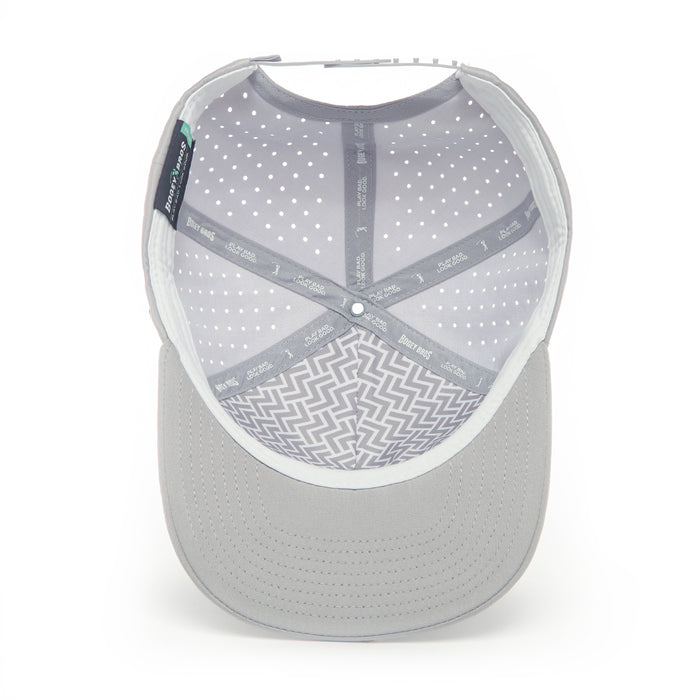 The Curves Right Performance Golf Hat - Snapback is light gray, shown from above with a visible interior lined with white polka dots, zigzag patterns, and branded trim. Made of sweat stain resistant material, it features stitched brim lines and a snapback closure.