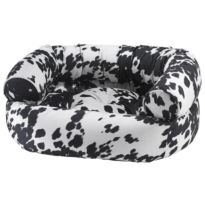 Black and white cow print pet bed on a white background