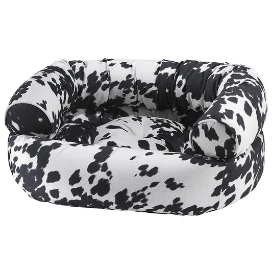 Black and white cow print pet bed on a white background
