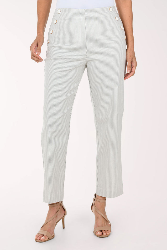 A model wearing light sage green pinstriped trousers with decorative gold buttons on the sides, paired with beige strappy high-heeled sandals against a plain white background.