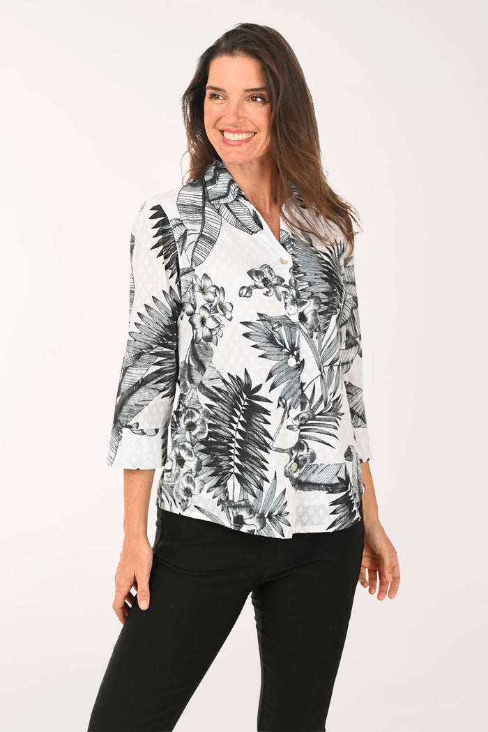Woman wearing a black and white floral blouse with a white background