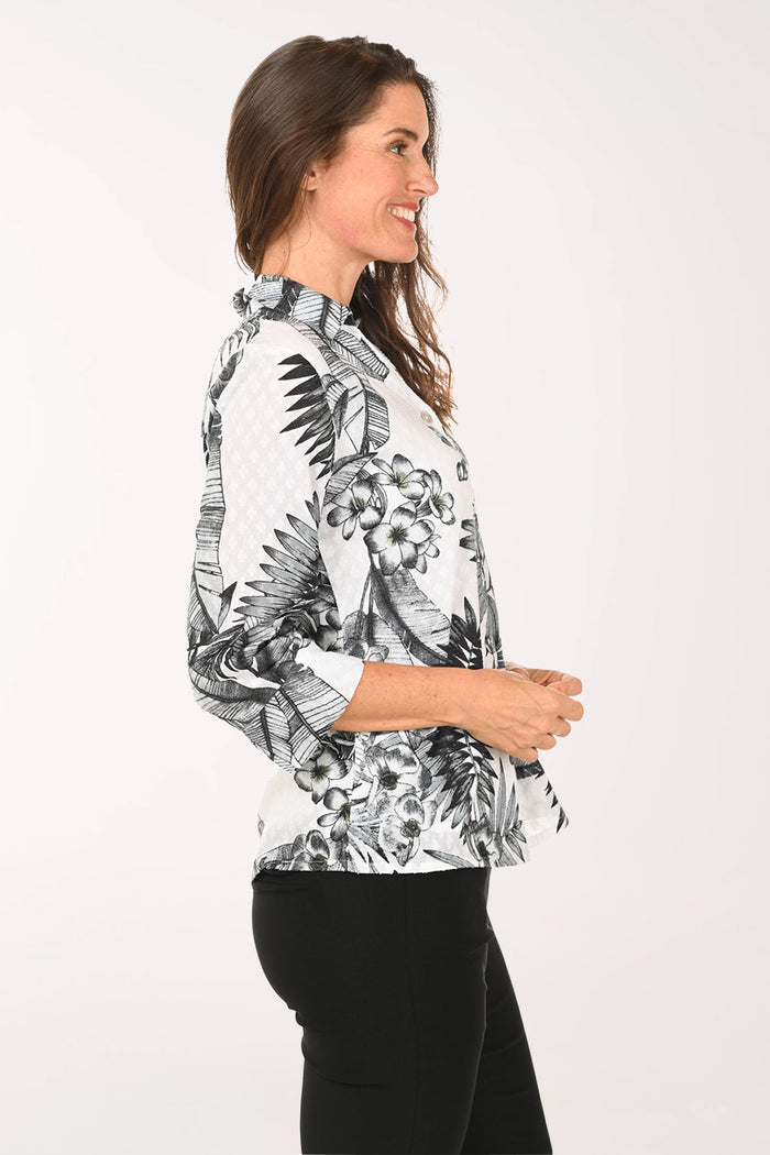 Woman wearing a black and white floral blouse with a white background