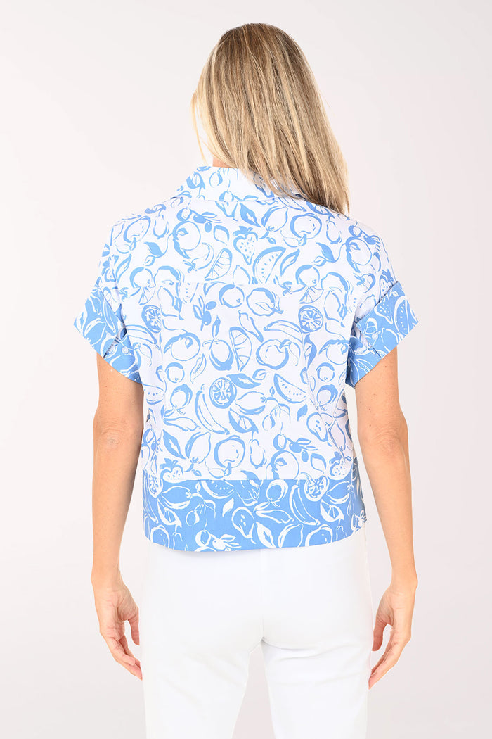 Woman wearing a blue and white patterned blouse on a white background