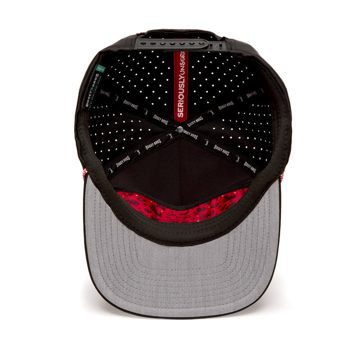 The image shows the inside of a flat-brimmed snapback hat. The interior features black fabric with white polka dots, a red “SERIOUSLY VANS” label, and a grey underside of the brim with a red and black pattern near the edge.