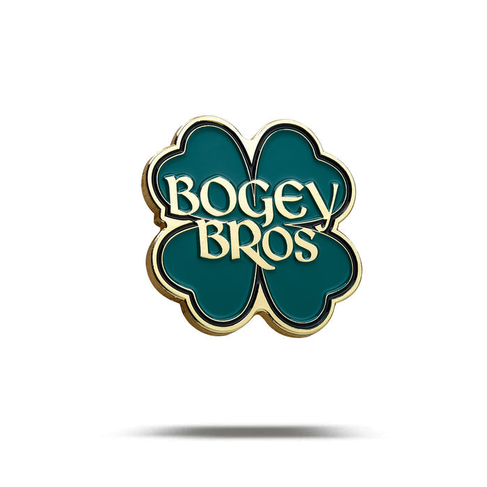 The Gettin' Lucky - Ball Marker is a green four-leaf clover pin with gold edges and iron/nickel plating. "BOGEY BROS" appears in bold, gold letters at the center, all set on a white background with a subtle shadow beneath.