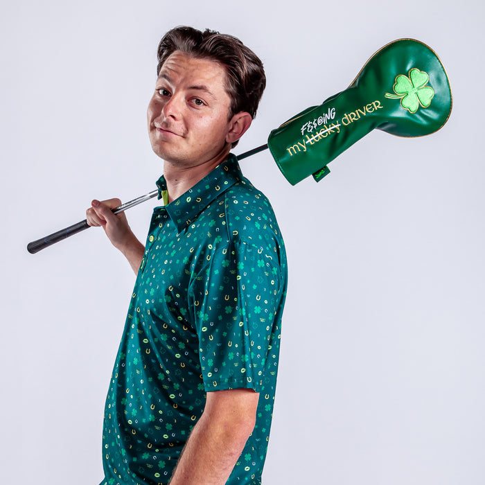 A man in a green shirt with yellow horseshoes holds a golf club over his shoulder, featuring the Gettin' Lucky Driver Headcover—premium PU leather with an embroidered four-leaf clover and "F#@%ING MY LUCKY DRIVER.