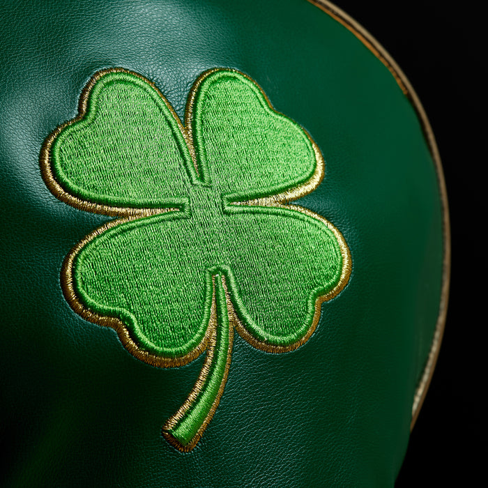 Close-up of the Gettin' Lucky - Driver Headcover, crafted from premium PU leather. Features a gold-outlined, embroidered green shamrock with textured stitching and finished with elegant gold edge trim.