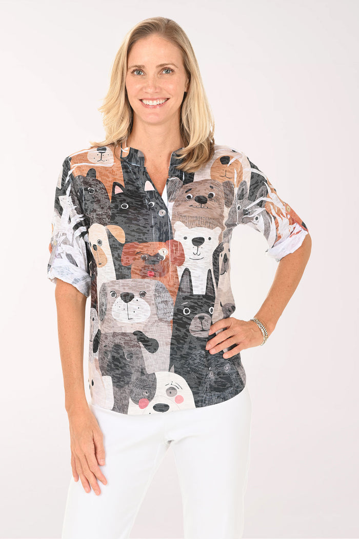 Woman wearing a patterned blouse with animal faces on a white background