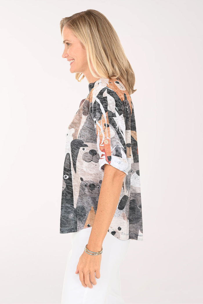Woman wearing a patterned blouse with animal faces on a white background