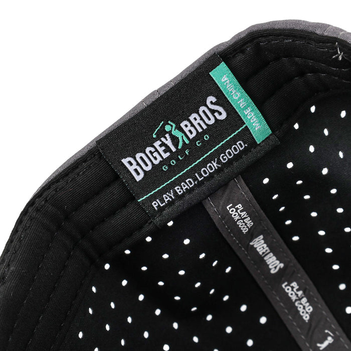 Close-up of the inside of the "I'd Tap That - Performance Golf Hat - Snapback," featuring a black interior with white polka dot lining, visible stitching, and brand tags reading “BOGEY BROS GOLF CO.,” “PLAY BAD. LOOK GOOD.,” and “MADE IN CHINA.”.