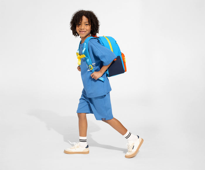 A child model wearing the Kids Backpack in Splash Blue with the chest strap in use // Daniel, age 8, wears the Kids Backpack in Splash Blue.