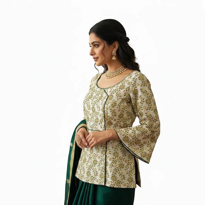Kurti Connection USA long blouse in cream with floral embroidery, bell sleeves, and green trim worn with a lehenga