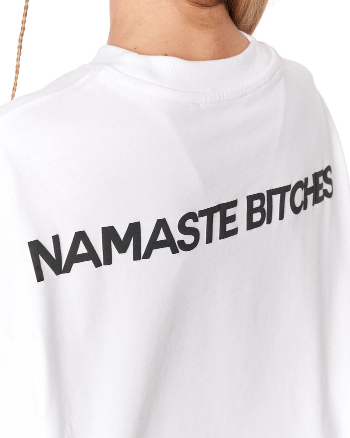 A close-up of a person wearing a white crewneck t-shirt with the text 'NAMASTE' printed in bold black letters across the back.