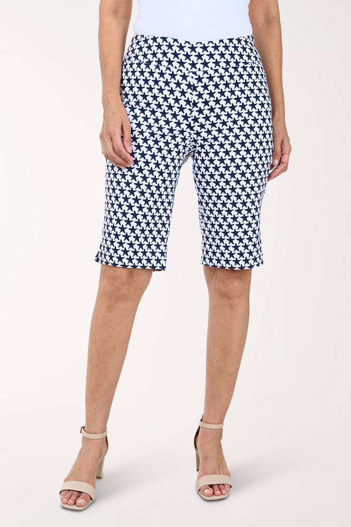 Person wearing navy and white patterned shorts on a white background