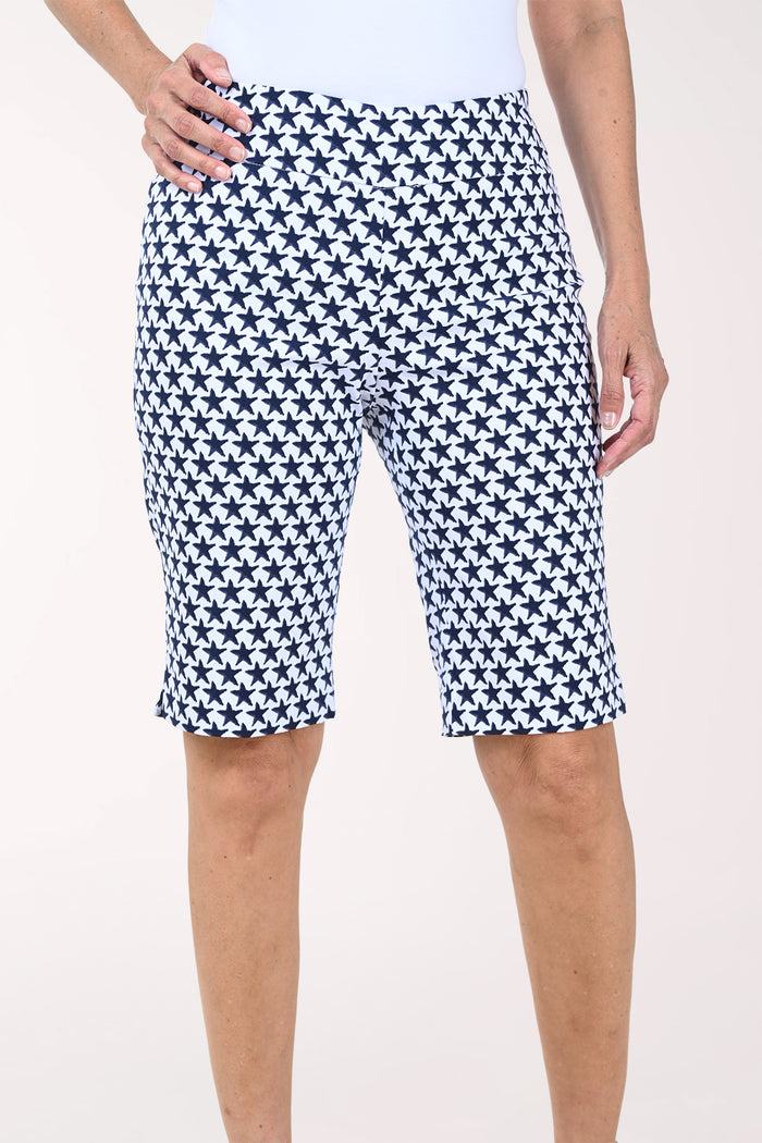 Person wearing navy and white patterned shorts on a white background