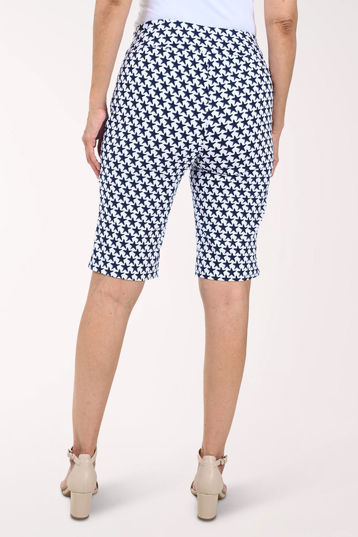 Person wearing navy and white patterned shorts on a white background