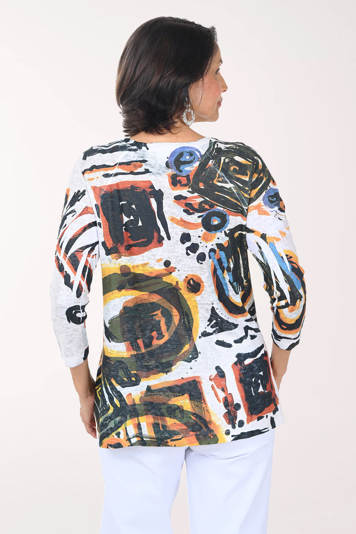 Woman wearing a colorful abstract patterned top against a white background