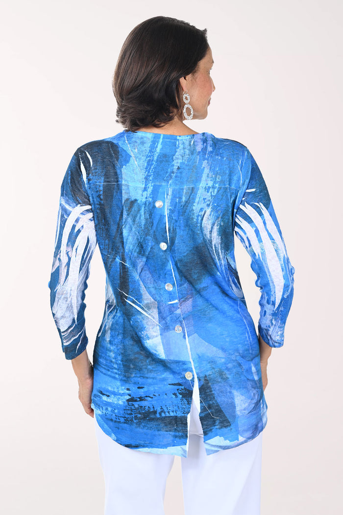 Woman wearing a blue abstract patterned top on a white background