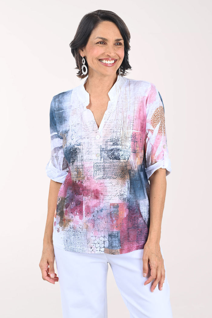 Woman wearing a colorful patterned blouse with a plain background