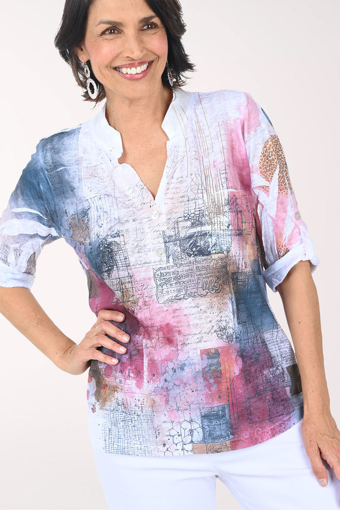 Woman wearing a colorful patterned blouse with a plain background