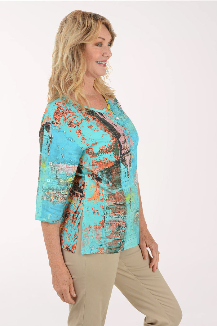 A woman wearing a multicolored blue top.