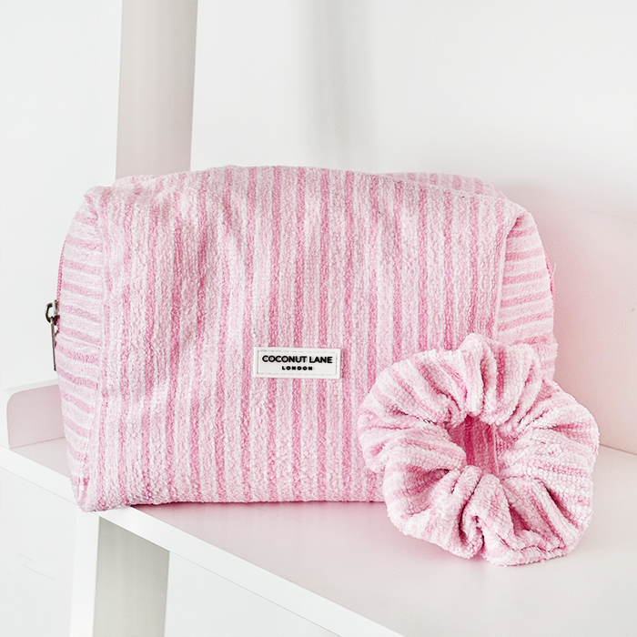 Coconut Lane makeup bag and scrunchie set with powder pink stripes, displayed on a white shelf.