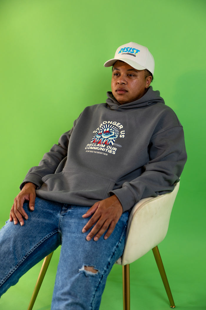 Donny, founder of 17th and Granville, wearing the Reclaim Our Communities hoodie with a Resist hat.