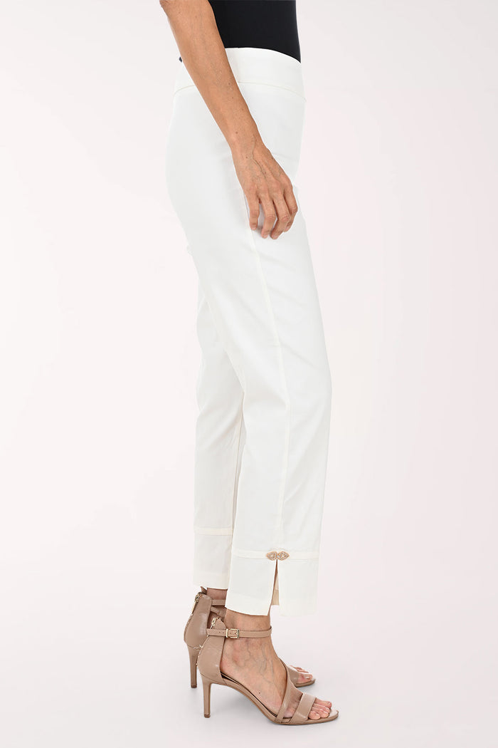 White cropped ankle pants with rolled cuffs and small side zippers, shown on a model wearing beige strappy heels against a plain light background.
