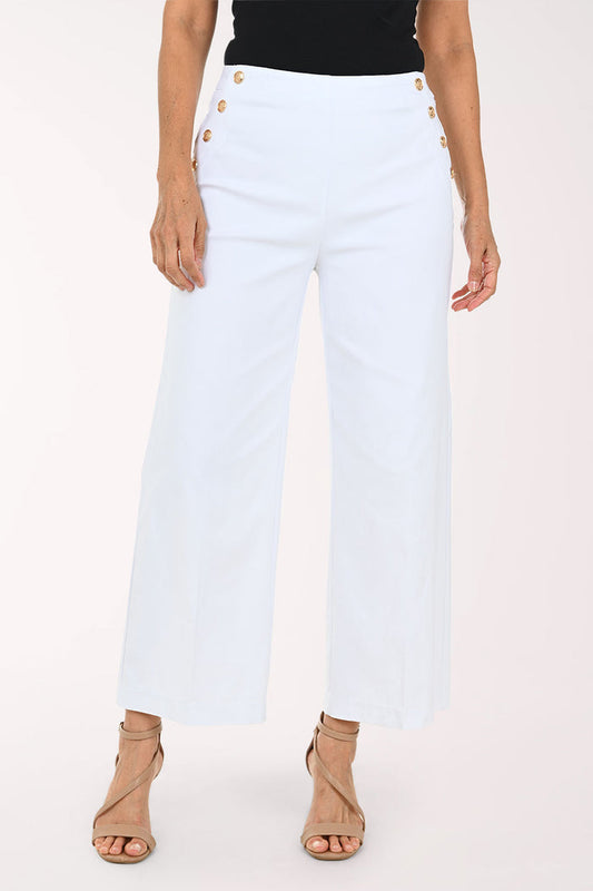 White cropped wide-leg pants with decorative gold-tone buttons on the sides, shown on a model wearing a black top and beige strappy heels against a light studio background.